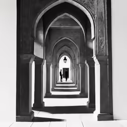 a hallway in a building with columns and two men standing under a lantern